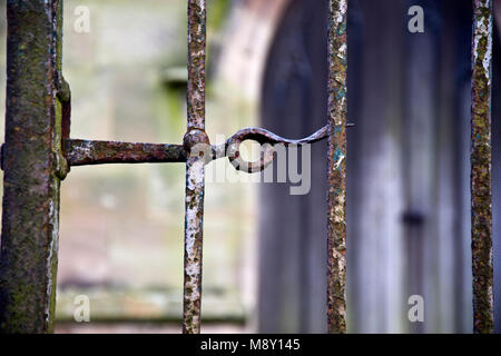 Old gate latch, with blurred Church doorway in the background. Stock Photo