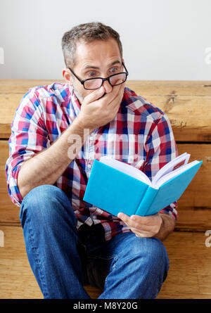 portrait of handsome bearded man reading a book Stock Photo