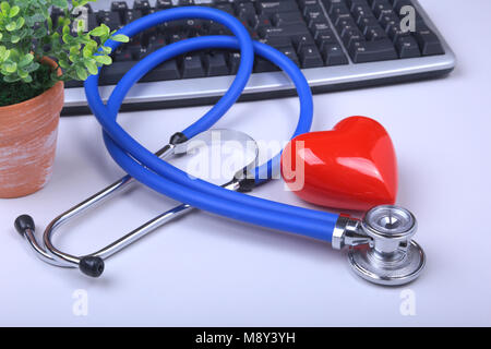 Stethoscope on modern laptop computer. red heart on white table with space for text. Healthcare concept Stock Photo