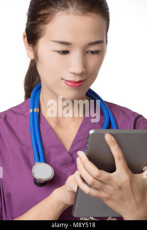 Beautiful Asian American doctor or nurse using a tablet computer with stethoscope isolated on white background Stock Photo