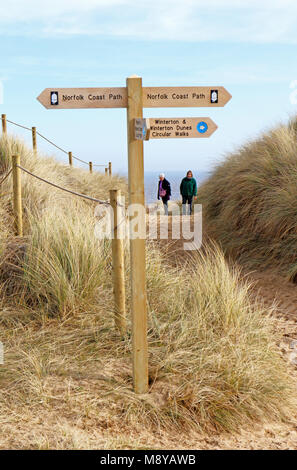 A sign post for the Norfolk Coast Path by access to the beach through dunes at Winterton-on-Sea, Norfolk, England, United Kingdom, Europe. Stock Photo