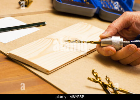 Carpenter adjusts drill bit in hand drill Stock Photo