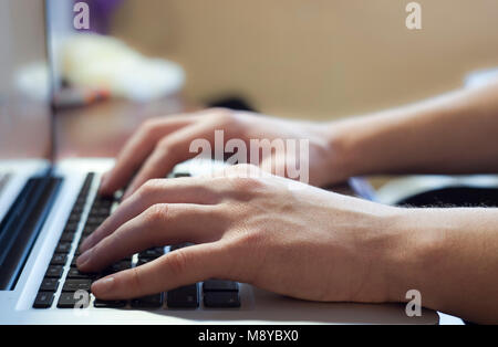 Hand typing on notebook keyboard Stock Photo