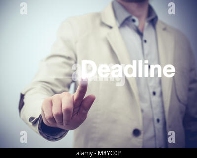 Businessman pressing on virtual screen and selecting deadline Stock Photo