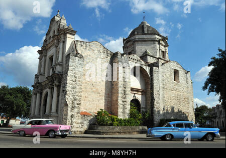 Colourful classic cars drive past the historic Iglesia de San Francisco de Paula (church) near the waterfront in Old Havana, Cuba. Stock Photo