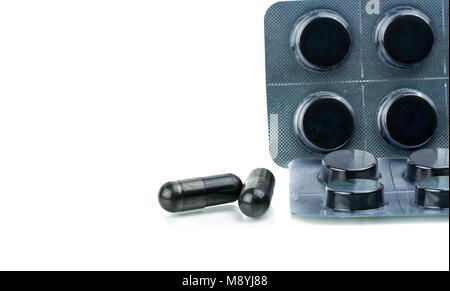 Activated charcoal tablets pills in blister pack isolated on white background with copy space for text. Black round tablets pills and capsule pills fo Stock Photo