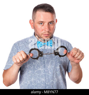 Adult male with beard in a blue bow tie in summer shirt in police handcuffs isolated on a white background Stock Photo