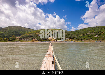 Long wooden pier on Apraos beach near Kassiopi town. Corfu island. Greece. Stock Photo