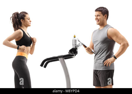 Fitness woman exercising on a treadmill with a personal trainer isolated on white background Stock Photo