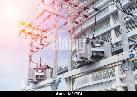 Power in urban: electrical post with power line cables transformers against office building Stock Photo