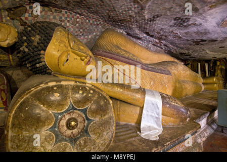 An interior view of a sleeping lying reclining Bhudda in one of the caves at the Dambulla cave temple aka the Golden Temple of Dambulla. Stock Photo