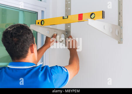 Technicien using Clinometer Bubble Level Ruler tool to install rack for straight and balance Stock Photo