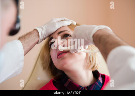 Check up in clinic of ear-throat-nose. Ent doctor check nose of female patient. Stock Photo