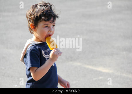 London, UK - July 09, 2017 - Little boy eating ice lolly at South Bank in hot weather Stock Photo