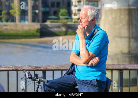 London, UK - July 09, 2017 - A grey-haired man looking over the riverside at South Bank in a hot weather Stock Photo