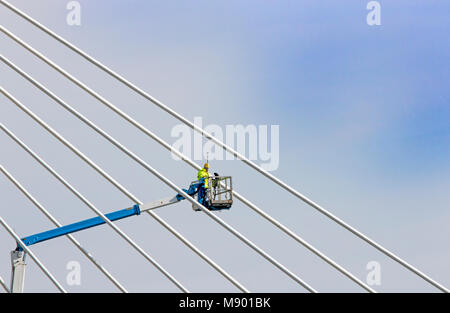 Mobile elevated work platform, telescopic construction worker working at height on the Marine Lake suspension bridge in Southport Merseyside, UK Stock Photo