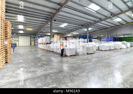 group of workers in the logistics industry work in a warehouse with chemicals Stock Photo