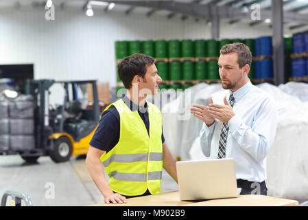managers and workers in the logistics industry talk about working with chemicals in the warehouse Stock Photo