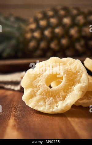 Dried and candied pineapple rings on wooden background Stock Photo