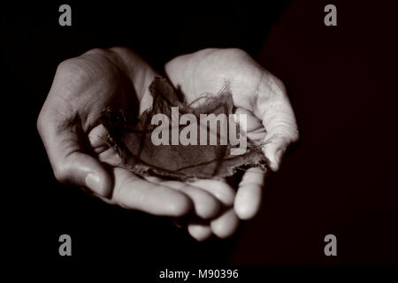 closeup of a ragged Jewish badge in the hands of a man, with a dramatic effect Stock Photo