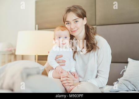 Portrait Mother plays with children on the bed.  Stock Photo