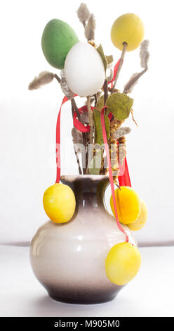 On white background is a vase with eggs on twigs of willow. Easter decoration. Stock Photo