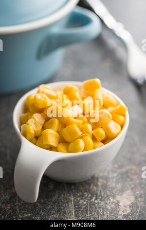 Corn seeds in bowl on kitchen table. Stock Photo