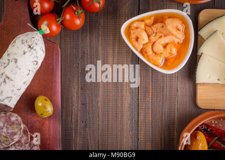 Mixed tapas food starters on table. Salami with walnuts, shrimps and manchego cheese. Top view. Copy space. Stock Photo