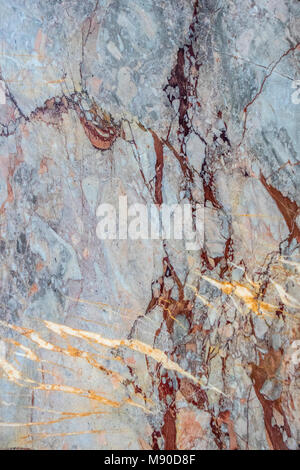 Rich blue streaked marble with red and gold veins and striking colours suitable for use as high resolution textured background Stock Photo