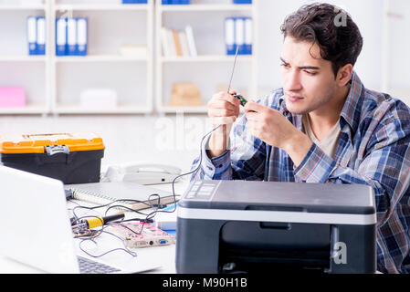 Hardware repairman repairing broken printer fax machine Stock Photo