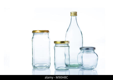 Empty clear glass bottles in various sizes and shapes with lids on white background Stock Photo