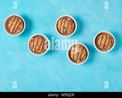 Safe-to-eat raw monster cookie dough in small portion bowl on blue background. Ideas and recipes for kids and toddlers meal. Top view or flat-lay. Copy space for text. Stock Photo