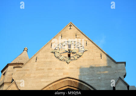 Antique clock at the chirch wall on blue sky background Stock Photo