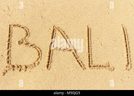 The inscription on the sand of Bali. Vacation time, beach holidays. Stock Photo