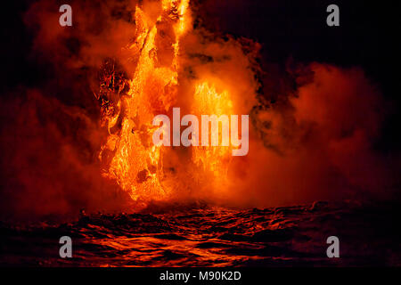 Sea water and molten rock splatter just before sunrise as Pahoehoe lava flowing from Kilauea reaches the Pacific ocean near Kalapana, Big Island, Hawa Stock Photo