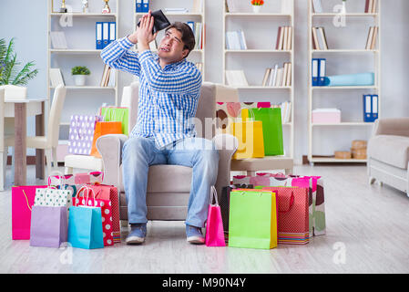 Young man after excessive shopping at home Stock Photo