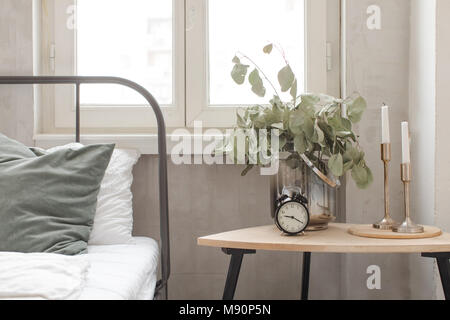 Bedroom interior clock plant pot on wooden table Stock Photo