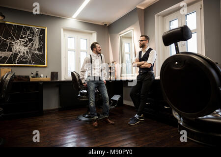 Portrait of two barbers talking in salon Stock Photo