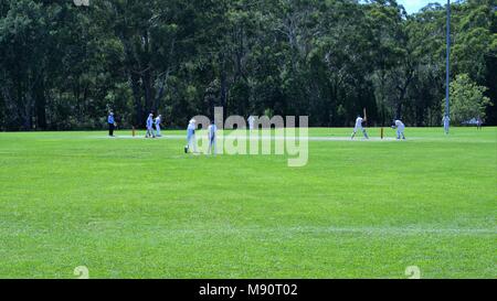 Dated 20 Mar 2018. Cricket match played on ground in Coffs Harbour, New South Wales, Australia. Wide shot of unidentifiable cricketers playing cricket Stock Photo