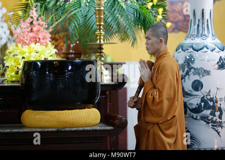 Truc Lam buddhist temple. Young monk using giant singing bowl.   Dalat. Vietnam. Stock Photo