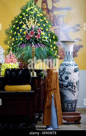 Truc Lam buddhist temple. Young monk using giant singing bowl.   Dalat. Vietnam. Stock Photo