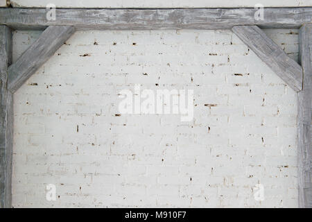 Gray wooden beams against a white brick wall. Stock Photo