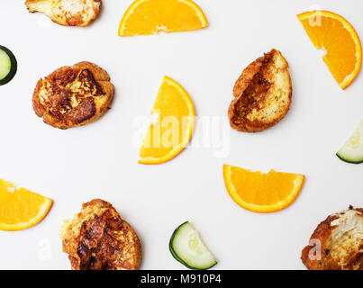 Breakfast pattern: french toasts, sliced oranges and cucumbers on a white table top. Stock Photo