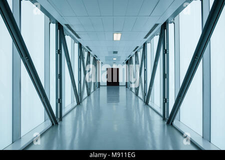 empty long corridor in modern building, might be an office, public building, exhibition grounds or an airport. Stock Photo