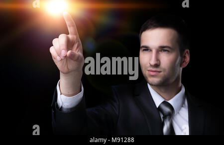 Business man pressing an imaginary button. Isolated on black. Stock Photo