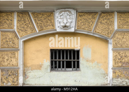 RUSSIA, SAINT PETERSBURG - AUGUST 18, 2017: Plaster head of a lion on the facade above a window with a lattice Stock Photo