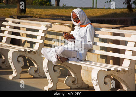 Old man reading a book at Birla Ganapati temple, Somatane Toll Plaza at Pune Stock Photo