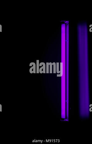 Neon glow light on the wall.Blurred because low light in the dark. Stock Photo