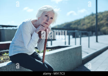 Pensive elderly lady looking into sky Stock Photo