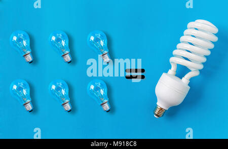 Spiral lightblub and old lightblubs on the blue background.A comparison of energy savings Stock Photo